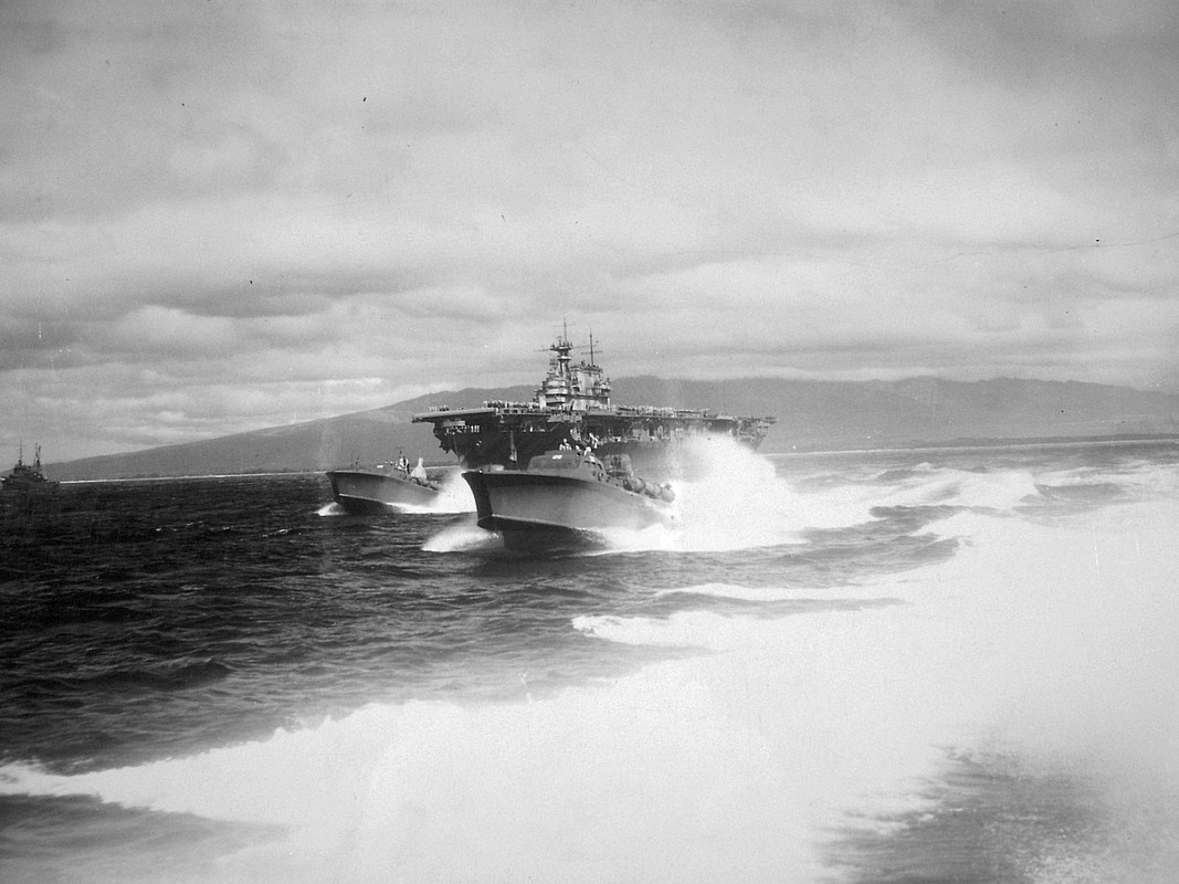 El USS Hornet CV-8 llega a Pearl Harbor después de la Incursión de Doolittle, el 30 de abril de 1942. Las Lanchas USS PT-28 y la USS PT-29 en primer plano