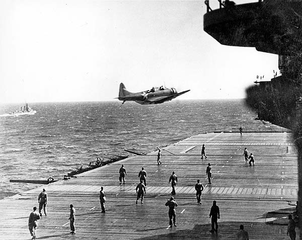 Un Douglas SBD Dauntless pasa lentamente sobre la cubierta del USS Enterprise para lanzar un mensaje durante el Raid de Doolittle el 18 de mayo de 1942