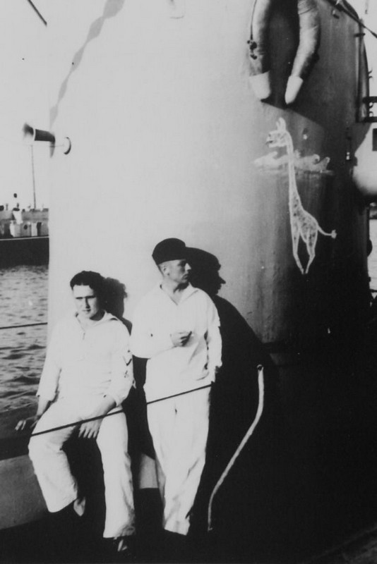Miembros de la tripulación descansan apoyados en la torreta o vela del U-17