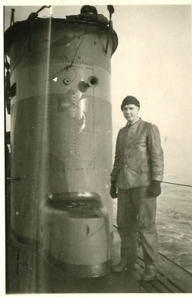 Un miembro de la tripulación posa ante la vela del U-26