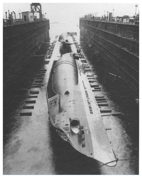 El U-18 en primer plano y el U20 en dique seco en el proceso de colocar los pontones laterales antes de ser transportados por el canal de Kiel