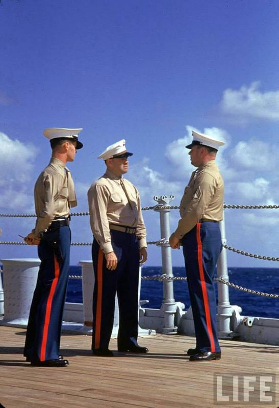 Tres marines estadounidenses vestidos de uniforme hablan a bordo de un barco no identificado durante las maniobras de la flota de la Armada de los EE. UU. Cerca de Hawai, en septiembre de 1940