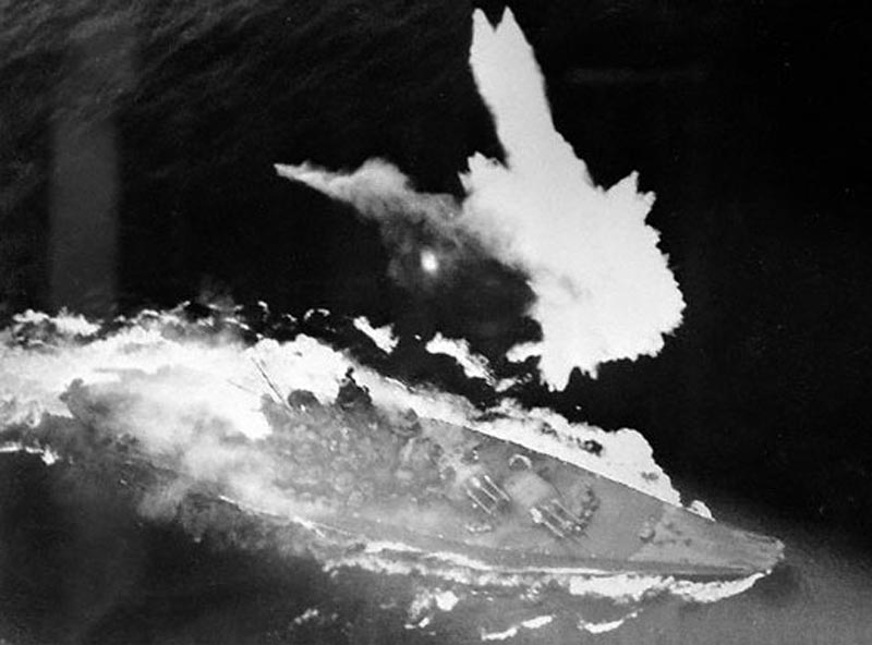 El acorazado IJN Yamato hundiéndose por popa y con la parte posterior de su superestructura en llamas