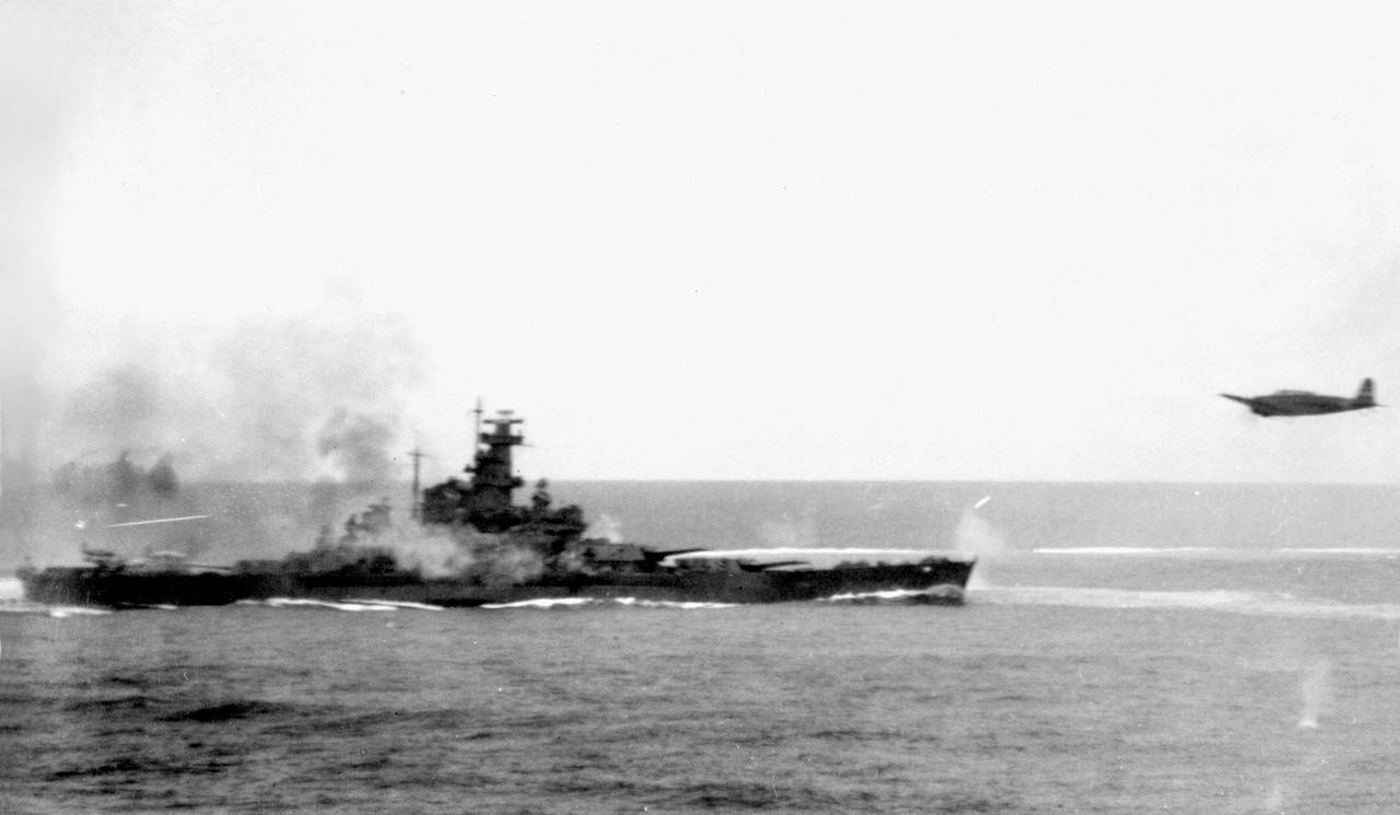 El Acorazado USS South Dakota BB-57 disparando sus cañones antiaéreos contra aviones japoneses durante la Batalla de Santa Cruz, el 26 de octubre de 1942. Un torpedero Nakajima B5N2 es visible a la derecha, aparentemente abandonando el área después de haber dejado caer su torpedo