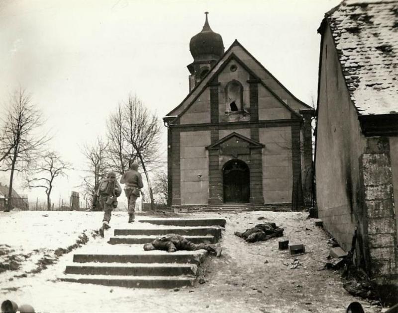 Después de tres días de batalla, esta ciudad fue finalmente recuperada de los nazis. La patrulla está a punto de entrar en una iglesia para examinar el campanario y bodega donde aún pueden esconderse francotiradores