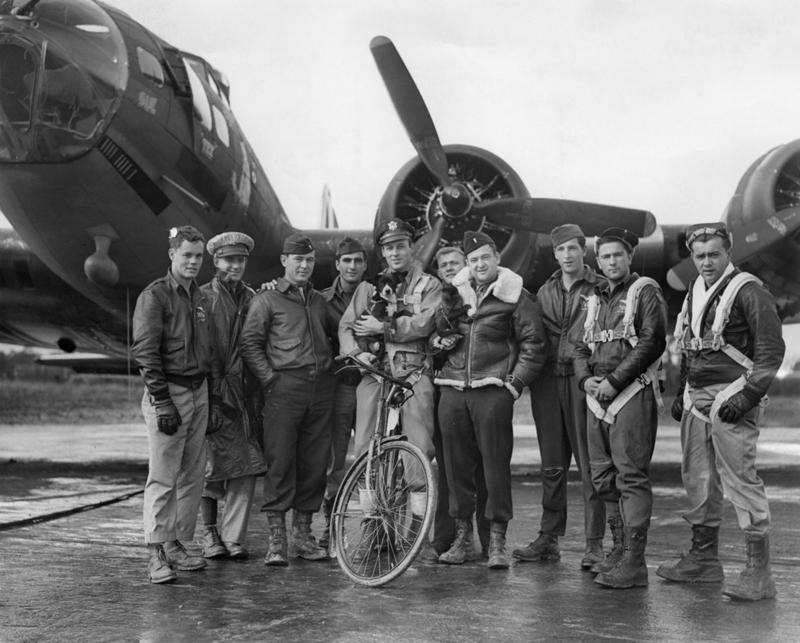 El piloto estadounidense Robert W Biesecker y su tripulación posan con sus dos mascotas, un perro llamado Scrappy y un mono llamado Joe. 18 de octubre 1943