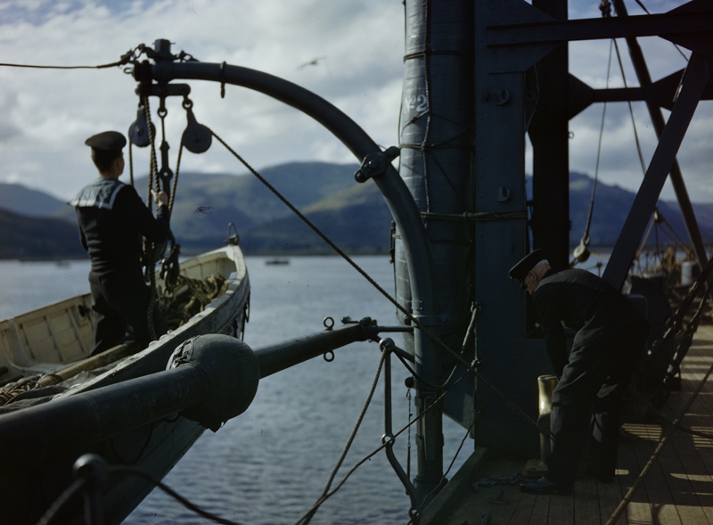 Un oficial y un marinero lanzan un bote del HMS Forth en Holy Loch, Escocia, 1942