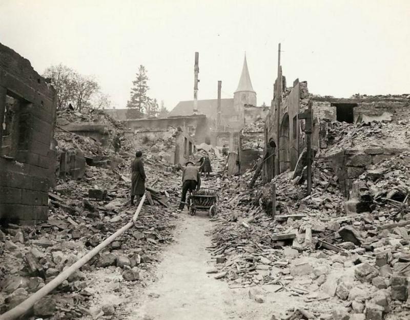 Civiles alemanes en medio de su pueblo destruido en el marco del conflicto militar