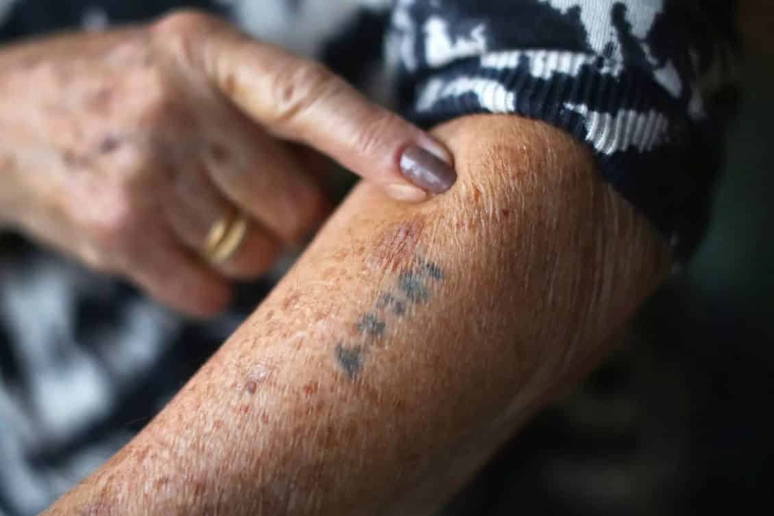 La superviviente del campo de concentración de Auschwitz y Belsen, Eva Behar, muestra el número de prisionera tatuado en su brazo por sus captores nazis. Christopher Furlong. Getty Images