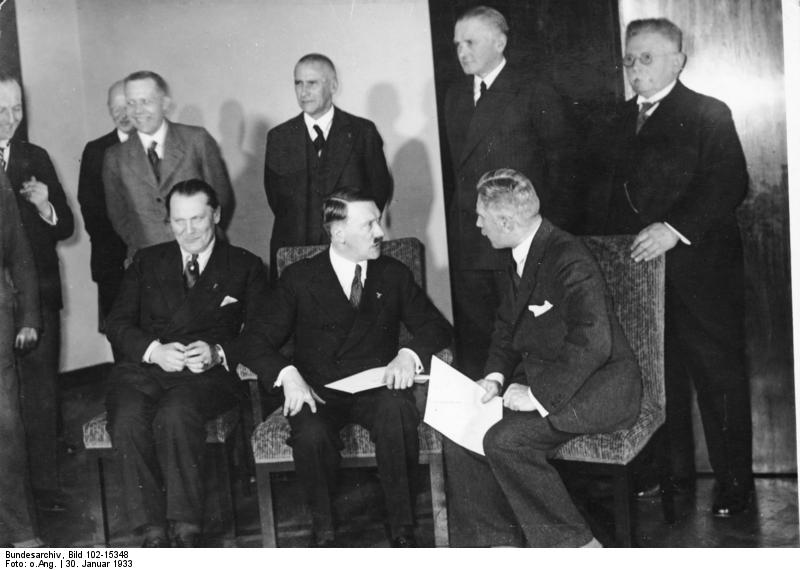 El histórico 30 de enero de 1933 en Berlín. Después de la primera sesión del nuevo Gabinete del Reich, presidido por el Canciller del Reich Adolf Hitler, a las siete y media de la tarde en la Cancillería del Reich. En la primera fila de izquierda a derecha, Ministro Presidente Hermann Goering, Canciller Adolf Hitler, y vicecanciller von Papen. De pie de izquierda a derecha, Reichsminister v. Schwerin-Krossik, Ministro del Interior del Reich Frick, ministro de Reichswehr v. Blomberg, y el ex Reichsnährungsminister Dr. Hugenberg