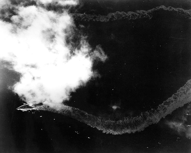 El Yamato dibuja una estela en zigzag mientras da golpes de timón intentando dificultar el acierto de las bombas y los torpedos que dejan caer las aeronaves durante la Operación Ten-Gō