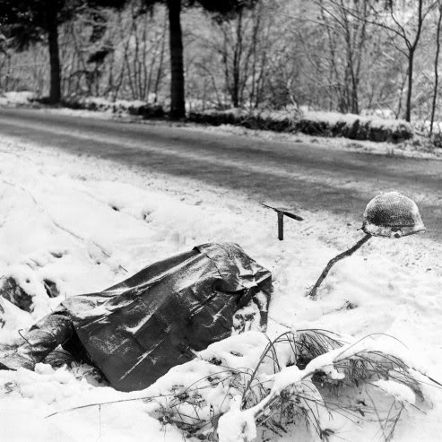 Cuerpo de un desconocido soldado americano espera sepultura al lado de una carretera en las Ardenas, enero de 1945