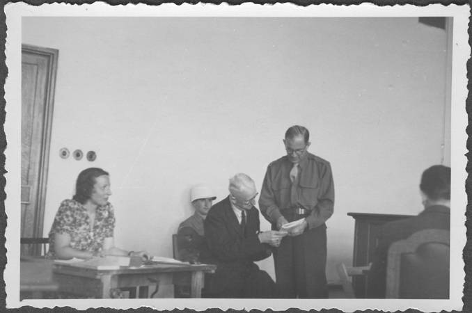 El fiscal estadounidense Robert Kempner muestra un documento al mariscal de campo alemán Erich von Manstein, en las audiencias de la comisión del Tribunal Militar Internacional de Núremberg que investigaban las organizaciones nazis acusadas. En la fotografía también aparece la intérprete, la señora Lowenstein. Julio de 1946