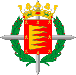 Escudo de la Ciudad de Valladolid. Representa una Cruz Laureada de San Fernando concedida a toda la Ciudad por Francisco Franco en 1940 por su participación en la Guerra Civil en pro del Bando Faccioso