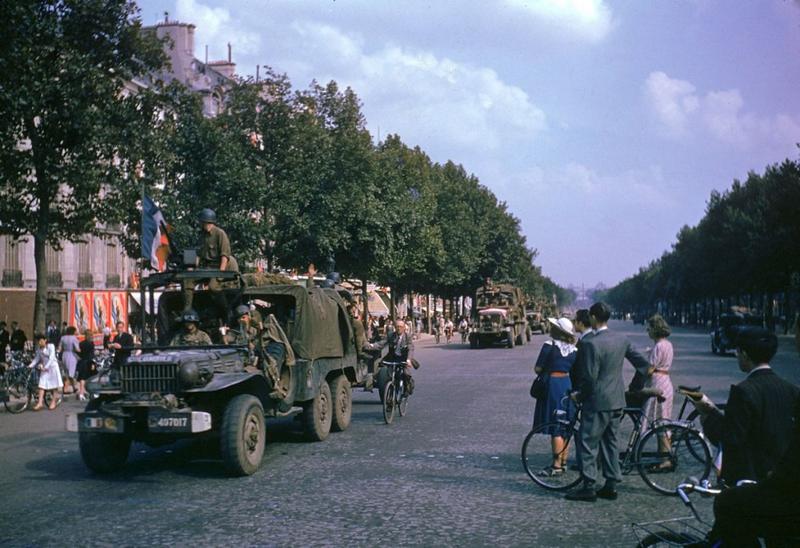 Camiones del ejército estadounidense, obsérvese el ciclista, circula por los Campos Elíseos, el día después de la liberación de París por las tropas aliadas, agosto de 1944