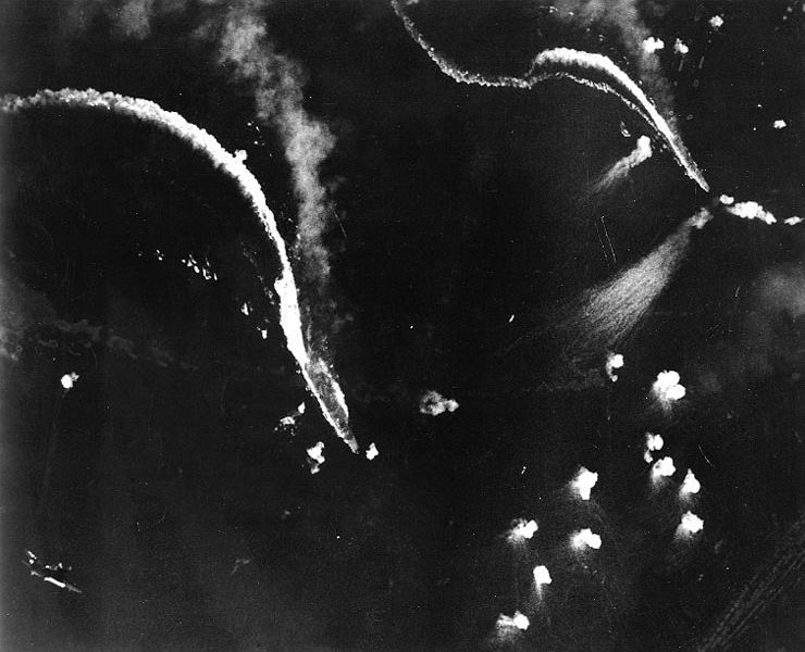 El IJN Zuikaku, en el centro y el IJN Zuiho, a la derecha bajo ataque de bombarderos en picado SB2C