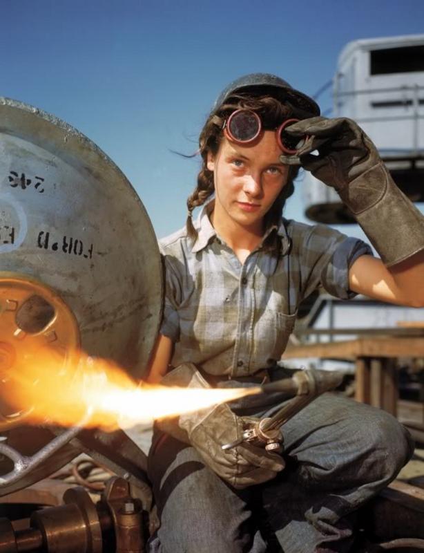 Una jovencísima soldadora de un astillero se ajusta las gafas protectoras antes de reanudar el trabajo, octubre de 1943