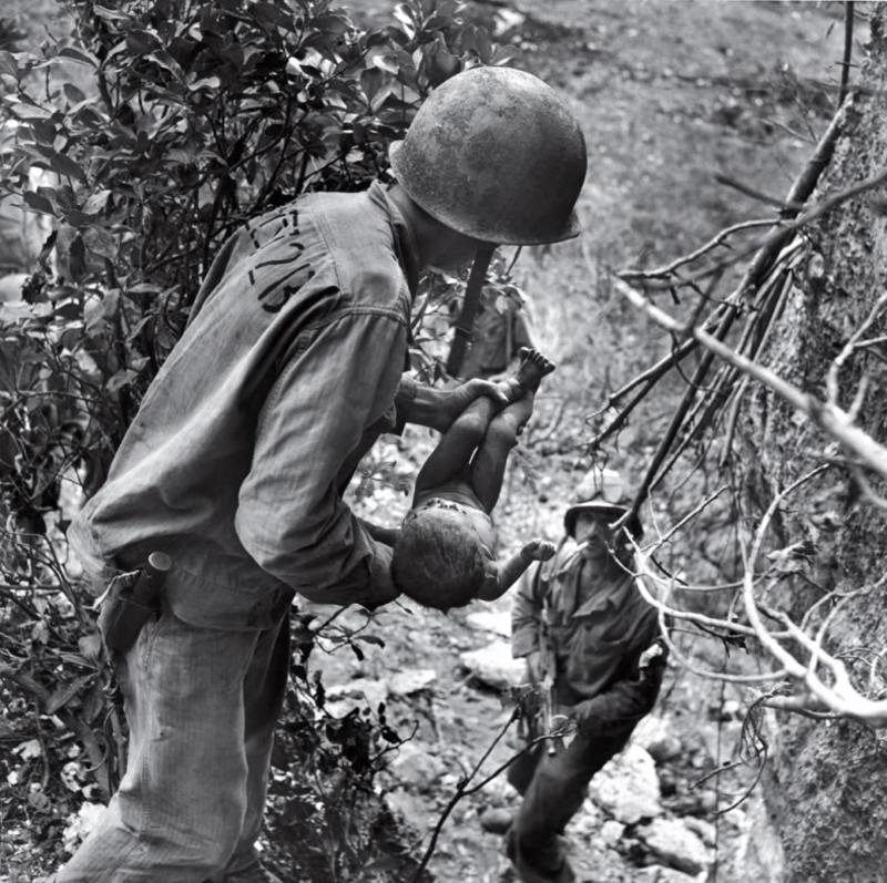Dos marines extraen a un bebé casi muerto de debajo de unas rocas en el verano de 1944. El niño era la única persona encontrada con vida entre los cientos de cadáveres en una cueva. Timepix - Time Life Pictures - Getty Images. Time Life Pictures